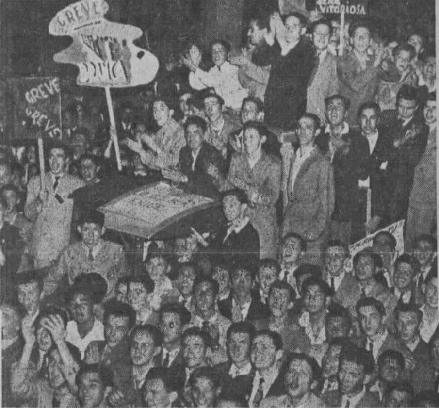 Fotografia em preto e branco, uma multidão no centro de  Porto Alegre em 1947, algumas pessoas estão em cima de um veículo, segurando cartazes e  outras no chão ao lado do veículo. [Fim da descrição]